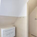 Badezimmer mit Dusche, Waschbecken und Fenster