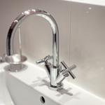 Moderne Waschbecken mit chromfarbenem Wasserhahn und zwei Handgriffen.