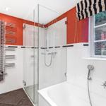 Badezimmer mit Dusche, Badewanne und Fenster