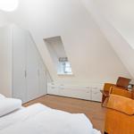 Schlafzimmer mit Dachschräge, Bett, Kleiderschrank und Fenster