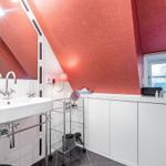 Badezimmer mit rotem Dach, Waschbecken und Fenster
