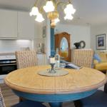 Round table with chairs, kitchen and living area in background.