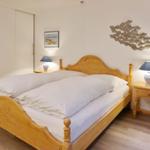 Bedroom with wooden bed, nightstands, and wall decoration.