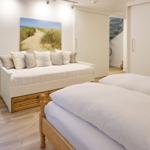 Bedroom with bed, daybed, and wall art