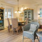 Dining room with table, chairs, and bookcase. TV and decor are visible.