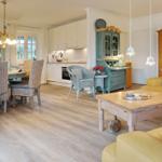 Living and dining area with kitchen, wooden floor, and furniture.