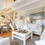Wohnzimmer mit Sofa, Couchtisch und Blick in die Küche.