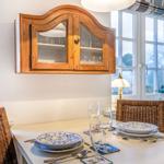 Dining table with chairs, cabinet, and windows