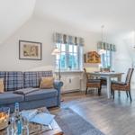 Living and dining area with sofa, table, and wooden cabinet.