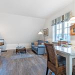 Living and dining area with sofa, TV, and dining table with chairs.