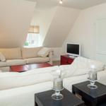 Living room with sofa, coffee table, and TV on the wall.