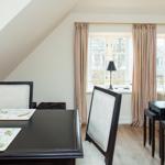 Dining room with table, chairs, and windows with curtains.