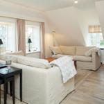Living room with sofa, windows, and wooden floor.