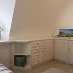 Bedroom with sloped ceiling, cabinet, and window