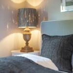 Bedroom with bed, nightstand, and lamp.