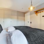 Bedroom with bed, coat rack, and ceiling lamp.