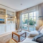 Living room with TV, bookcase, and view of the garden.