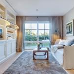 Living room with sofa, TV, and glass door to terrace.