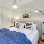 Schlafzimmer mit Bett, Kleiderschrank und Stehlampe.