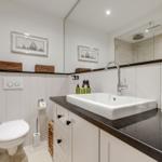 Badezimmer mit Waschbecken, Toilette und Spiegel