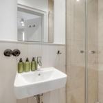 Bad mit Dusche, Waschbecken und Spiegel