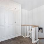Schlafzimmer mit weißem Schrank und Holzgeländer