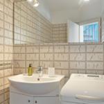 Badezimmer mit Waschmaschine und Spiegelschrank