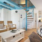 Wohnbereich mit Treppe zur oberen Etage und Küchenbereich im Hintergrund.