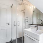 Bathroom with shower, sink, and heater.