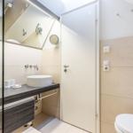 Badezimmer mit Waschbecken, Spiegel und Toilette