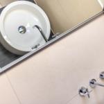 Waschbecken mit Spiegel und Duschbrause im Badezimmer