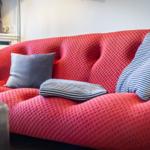 Ein roter Sofa mit Kissen und einem Beistelltisch.