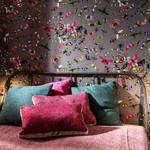 Schlafzimmer mit Bett und buntem Schmetterlings-Muster an den Wänden.