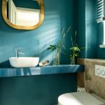 Badezimmer mit blauen Wänden, Waschbecken und Toilette.