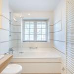 Badezimmer mit Badewanne, Dusche, Toilette und Fenster