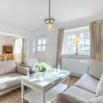 Wohn- und Essbereich mit Sofa, Tisch und Fenster