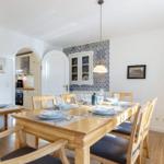 Esszimmer mit Holztisch, Stühlen und blau-weißem Fliesenwand