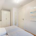 Schlafzimmer mit Bett, Kleiderschrank und Wandbild.
