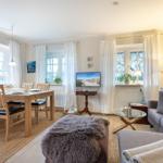 Wohn- und Essbereich mit Sofa, Esstisch und Fernseher.