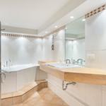 Badezimmer mit Badewanne, Waschtisch und Spiegel