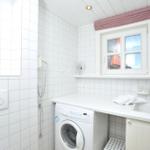 Waschraum mit Waschmaschine, Spüle und Fenster