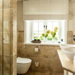 Badezimmer mit Dusche, Toilette und zwei Waschbecken