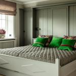 Schlafzimmer mit Bett, grünen Kissen und Fenster mit Vorhang.
