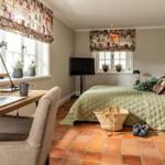 Schlafzimmer mit Arbeitsplatz, Bett und Terrakottboden