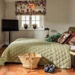 Schlafzimmer mit Bett, Fenster, TV und Bodenfliesen
