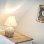 Bedroom with nightstand, lamp, and picture on the wall.