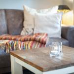 A living room with a sofa, a wooden table, and two tea lights.