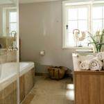 Bad mit Badewanne, Dusche, Waschbecken und Fenster.