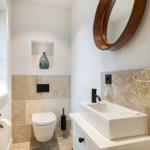 Badezimmer mit Waschbecken, Spiegel und Toilette