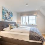 Schlafzimmer mit Bett, Fenster und Fernseher